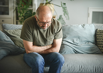 Man doubled over with prostate pain